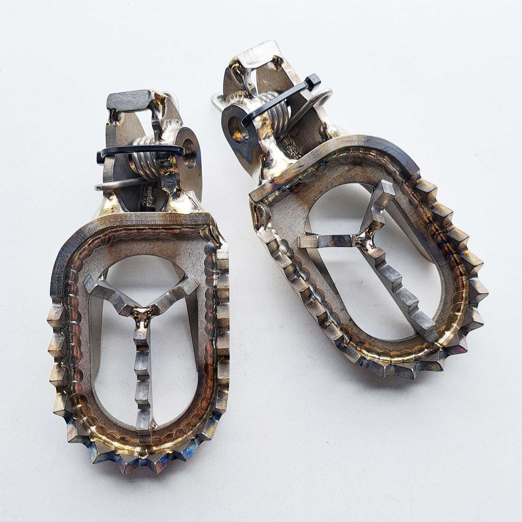 Apico - Foot Pegs - Titanium - BRACED - KTM SX85 18-25, SX125/150 16-22, SX250 17-22, SXF250-450 16-22, EXC/EXCF250-500 17-23, Husqvarna TC85 18-25, TC125 16-22, TC250 17-22, FC250-450 16-22, TE/FE 150-501 17-23, Gas Gas MC85 22-25, 125-450 21-23