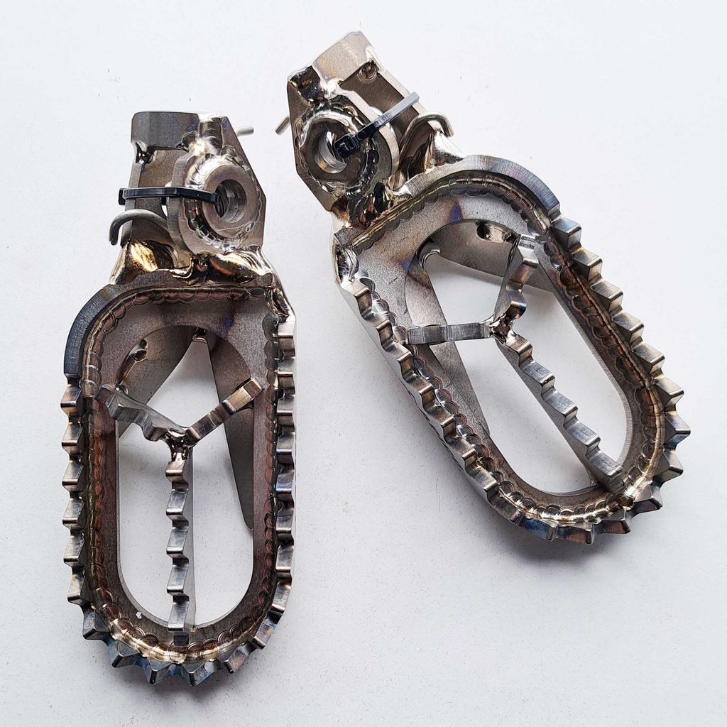 Apico - Foot Pegs - Titanium - BRACED - KTM SX/SXF 125-450 23-26, EXC/EXCF 125-450 24-26, Husqvarna TC/FC 125-450 23-26, TE/FE 125-450 24-26, TX300 23-26, FX350/450 23-26, Gas Gas 125-500 24-26, MCF250/450 FACTORY 23-26